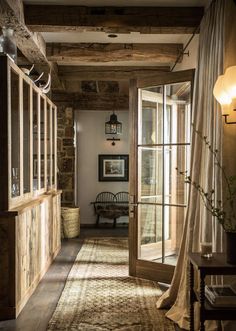 an open door leading into a room with wooden floors and walls, along with a rug on the floor