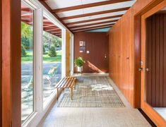 the hallway is lined with wood paneling and glass doors that lead to an outdoor swimming pool