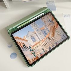 an open laptop computer sitting on top of a white table next to a notepad