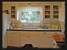 a kitchen with white cabinets and black counter tops is seen in this image from the inside