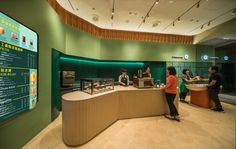 people are standing in front of a counter with food on it and a menu behind them