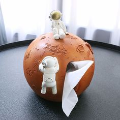 an astronaut figurine sitting on top of a piece of paper