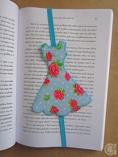 an open book with a paper cut out of the shape of a dress on it