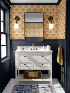 a bathroom with two sinks and a mirror on the wall above it is decorated in gold and blue