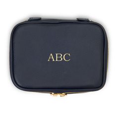 a black leather case with the word abc in gold lettering on it, sitting on a white surface