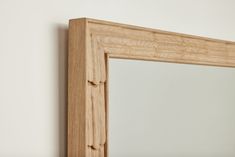 a wooden frame mirror hanging on the wall