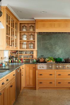 a large kitchen with wooden cabinets and stainless steel stove top oven in the center island