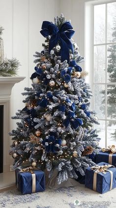 a blue christmas tree with presents under it