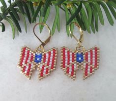 "These cute red, white, and blue ribbon bows with sparkling gold accents are wonderful gifts for any occasion. Exciting and meaningful, these earrings will enhance any outfit and will bring many compliments. These earrings are so light that they dance and sparkle with every move you make. Handmade with tiny glass beads they are as unique as they are adorable. The 18k plated gold lever back closures mean you don't have to worry about them slipping out of your earlobe. The dangle's length and the bow's width are close to 1\". AND they can also be purchased in several solid colors." Patriotic Handmade Earrings As A Gift, Patriotic Handmade Earrings For Gift, Handmade White Earrings For 4th Of July, Patriotic Earrings For 4th Of July Gift, 4th Of July Gift Drop Earrings, Seed Bead Bracelets Tutorials, Patriotic Earrings, Diy Seed Bead Earrings, Patriotic Jewelry