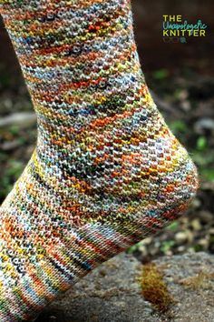 the feet of a person wearing socks made out of small multicolored knits