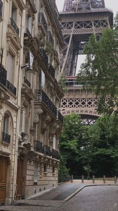 the eiffel tower is in the distance behind some buildings on a city street