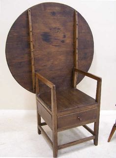 an old wooden chair sitting in front of a large round wall hanging on the wall