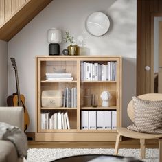 a living room filled with furniture and a clock above the bookshelf on the wall