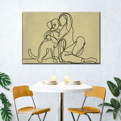 a table with two chairs and a painting on the wall above it that says love