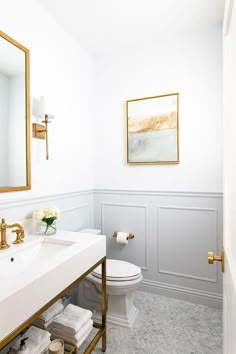 a bathroom with white walls and gold accents