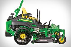 a green and yellow lawn mower sitting on top of a white surface