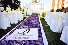 the aisle is decorated with white and purple flowers