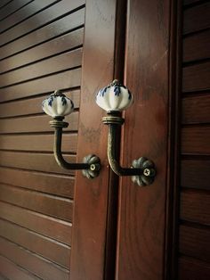 an ornate door handle with two blue and white glass knobs on it's side