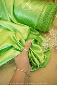 a woman in a green dress laying on top of a table