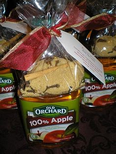 three jars of apple cider cookies wrapped in cellophane and tied with a red ribbon