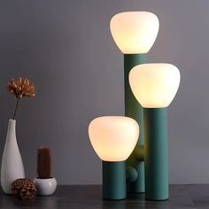 three vases and one lamp on a table