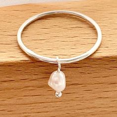 🌷These gorgeous little Pearl charm rings will also make a beautiful fidget ring. The tiny natural salt water Pearl moves around the band and looks extremely elegant. These rings are handmade and made to order in the size of your choice. Please choose the ring size of your choice from the drop down ring chart. 🌷Ring dimensions: 925 sterling silver 1.2mm gauge. Pearl charm: 6 mm 🌷Your beautiful ring will arrive gift wrapped and in a lovely gift pouch and will be sent first class with tracking. Dainty Sterling Silver Pearl Ring For Everyday, Adjustable Minimalist Sterling Silver Pearl Ring, Sterling Silver Pearl Drop Ring For Promise, Sterling Silver Pearl Drop Ring For Promise Occasions, Handmade Dainty Pearl Open Ring, Minimalist Stackable Sterling Silver Pearl Ring, Dainty Handmade Pearl Open Ring, Dainty Stackable Sterling Silver Pearl Ring, Silver Ring With Pearl Charm