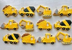 decorated cookies in the shape of trucks and construction vehicles are arranged on a white surface