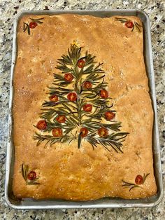 a christmas tree decorated on top of a cake in a metal pan with red and green decorations