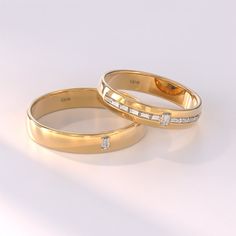 two yellow gold wedding bands with diamonds on each side, set against a white background