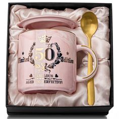 a pink coffee mug and spoon in a gift box with the number 50 on it