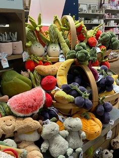 there are many stuffed animals on display in the store and one is holding a watermelon