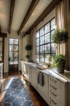 a large bathroom with two sinks and windows in the wall, along with a rug on the floor