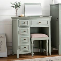 a green vanity with mirror and stool next to it