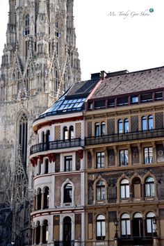 an old building with many windows and a clock tower in the back ground, next to other buildings