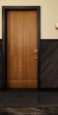 a wooden door in front of a white wall with black trim and wood paneling