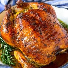 a roasted turkey on a platter with gravy and garnishes