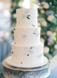 a white wedding cake with blue flowers on it