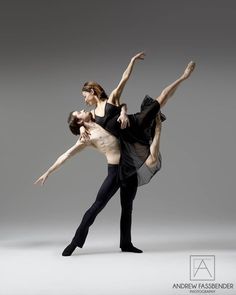 two dancers in black and white pose for the camera, with their arms around each other