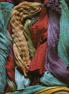 many different colored yarns are piled together