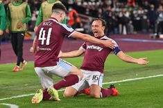 two soccer players are celebrating on the field