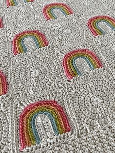 a crocheted blanket with rainbows on it