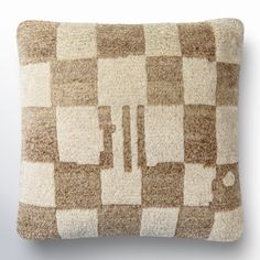 a brown and white checkered pillow sitting on top of a wall