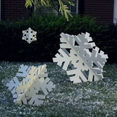 two snowflakes sitting in the grass next to each other