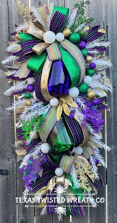 a wreath with purple, green and gold decorations