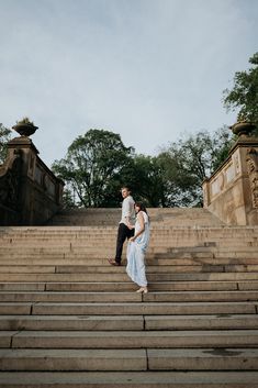 an engaged couple walking up some steps