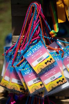 there are many tickets for the festival on this wooden stand with colorful cords hanging from it