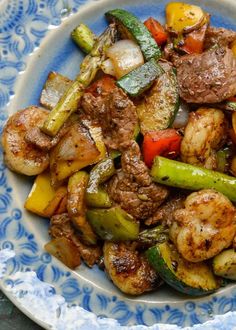 a blue and white plate topped with meat and veggies