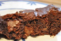 two pieces of chocolate cake sitting on top of a blue and white plate, one piece cut in half