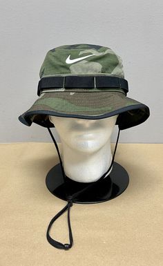 ~BRAND NEW w/ TAGS~ *100% AUTHENTIC*   Nike Boonie Dri-Fit Bucket Hat Color: Camo Style #: DM3331-222 Size: Medium/Large (Adult Unisex) The Nike Camo Bucket Hat comes directly from Nike. It is Brand New w/ Tags and never worn. It has been stored in a smoke free environment. Details: Stretchy, smooth and lightweight fabric is durable and flexible Drawcord with cord lock holds the hat in place while you move Webbing loops around the crown let you attach accessories Embroidered eyelets help keep your head cool Dri-FIT Technology helps keep your dry and comfortable Fabric 100% Polyester ----------- ** IN-HAND & READY TO SHIP **  ITEM WILL BE SHIPPED VIA USPS STANDARD MAIL 100% AUTHENTIC or 2x YOUR MONEY BACK!! ----------------------------------------- Item will be shipped by USPS Mail and with Camo Bucket Hat, Disney Desserts, Bucket Hat Style, Camo Style, Camo Fashion, Hat Cap, Office Wear, Nike Air Jordan, Lightweight Fabric