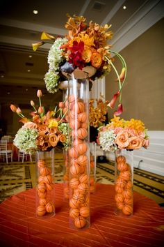 an arrangement of flowers in vases on top of a red carpeted flooring